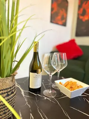 a bottle of wine and two glasses on a table at TLP Haven in Cape Town