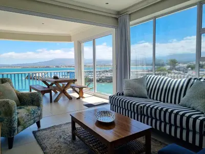 a living room with a view of the ocean at Penthouse on the beach, Jacuzzi with 3 bedrooms in Cape Town