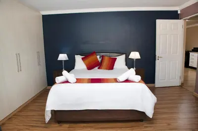 a bedroom with a large white bed with red pillows at 20 On Percy Unit 3 in Parkwood