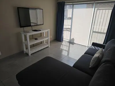 a living room with a couch and a television at Evert's Home in Bellville
