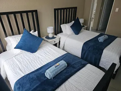 a room with two beds with blue pillows at Evert's Home in Bellville