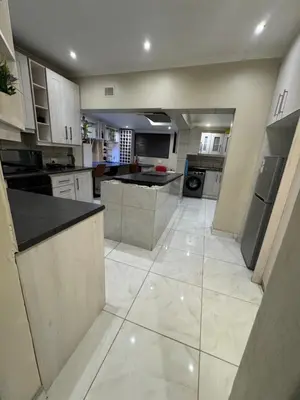 a large kitchen with white cabinets and appliances at Ewanges holiday home in Windsor Park