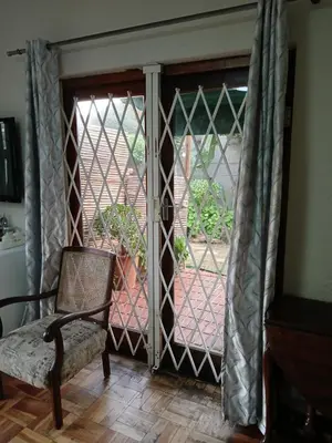 an open door with a chair in front of a gate at Rusticana A in Cape Town