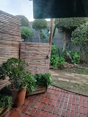 a garden with a wooden fence and some plants at Rusticana A in Cape Town