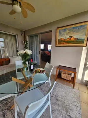 a living room with a glass table and chairs at Max 7 in Helderberg
