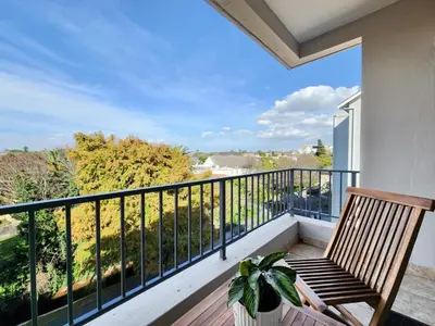 a balcony with a wooden bench and a view at Rivers Edge Apartment in Rondebosch with Balcony in Cape Town