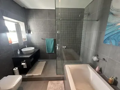 a bathroom with a tub and a toilet and a sink at Sunset Links Golf Estate home, walk to Beach in Cape Town