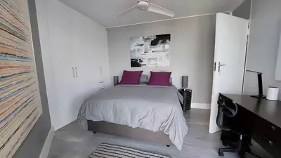 a bedroom with a bed with purple pillows at Views Views and more Views Stunning 2 bed Apartment in Strand