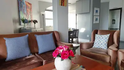 a living room with a couch and a vase with flowers at Views Views and more Views Stunning 2 bed Apartment in Strand