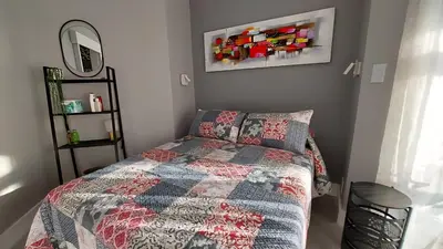a bedroom with a bed with a quilt and a mirror at Views Views and more Views Stunning 2 bed Apartment in Strand