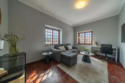 a living room with a couch and a table at Huguenot Franschhoek in Franschhoek