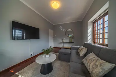 a living room with a couch and a tv at Huguenot Franschhoek in Franschhoek