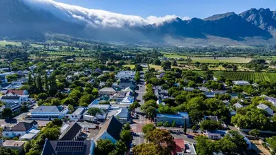 an aerial view of a small town with mountains in the background at Huguenot Franschhoek in Franschhoek