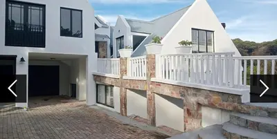a house with white walls and a balcony at Studio at Providence in Hermanus