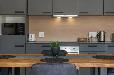 a kitchen with a wooden table with a potted plant on it at Bridgewater One 309 in Cape Town