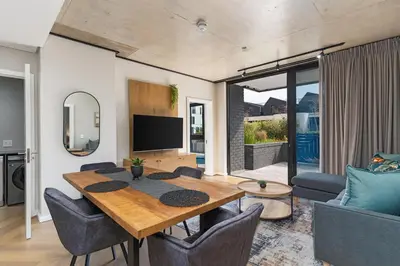 a living room with a wooden table and chairs at Bridgewater One 309 in Cape Town