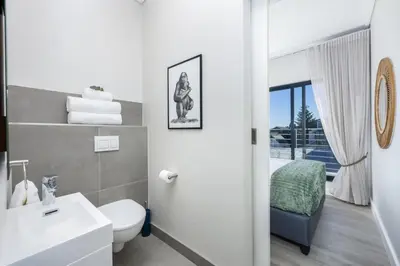 a bathroom with a toilet and a sink at Esplanade Hermanus Central Sea Views in Hermanus