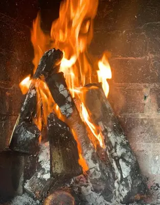 a fire is burning in a brick oven at Sealax Cottage Fleurpark in Gordonʼs Bay