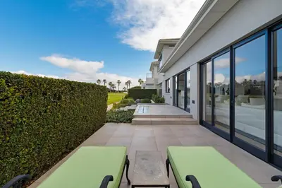 a patio with two benches next to a building at Sunset Fairway Vista Villa in Cape Town
