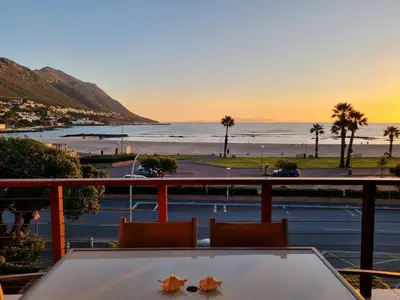 a view of the beach from the balcony of a resort at Flat 9, Beachfront 2 Bedroom with Sea View for 4 in Gordonʼs Bay