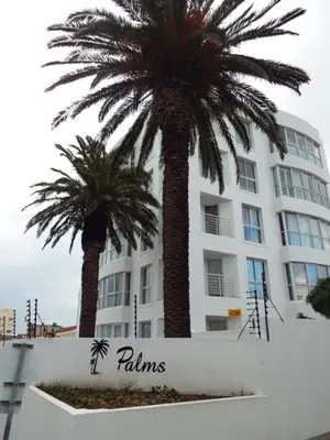 two palm trees in front of a building at Palmsbeach 5 in Strand