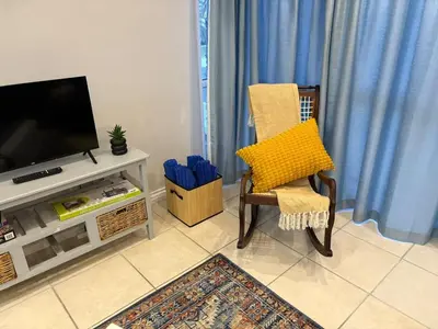 a living room with a chair and a television at Palmsbeach 5 in Strand