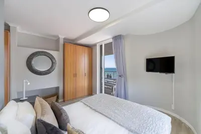 a bedroom with a white bed and a window at Horizon Bay 903 Fresh Beachfront Hideaway in Cape Town