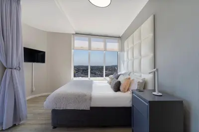 a bedroom with a large bed with a large window at Horizon Bay 903 Fresh Beachfront Hideaway in Cape Town