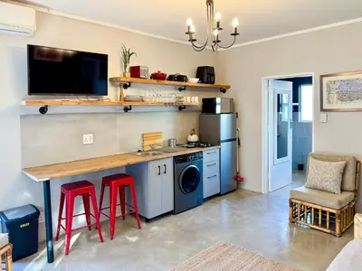 a kitchen with a counter and red stools at Dublin - 2 Bedroom Apartment in Blomtuin