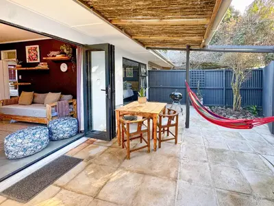 a patio with a table and chairs and a hammock at Dublin - 2 Bedroom Apartment in Blomtuin