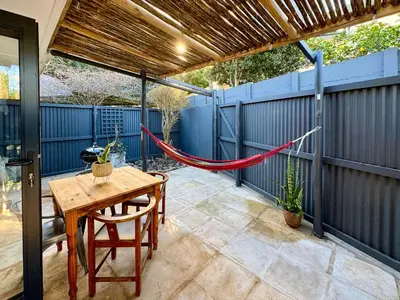 a patio with a hammock on a blue fence at Dublin - 2 Bedroom Apartment in Blomtuin