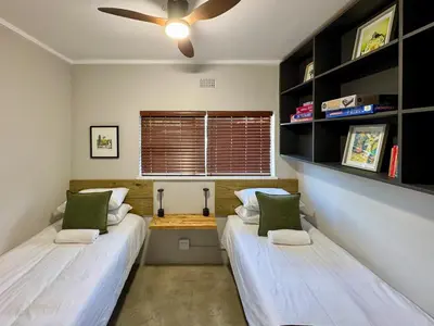 two beds in a room with a ceiling fan at Dublin - 2 Bedroom Apartment in Blomtuin