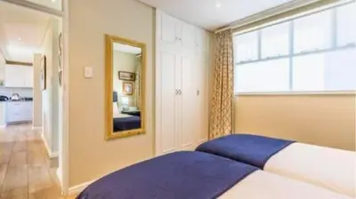 a bedroom with a large bed and a mirror at The Pearl in the Winelands in Paarl
