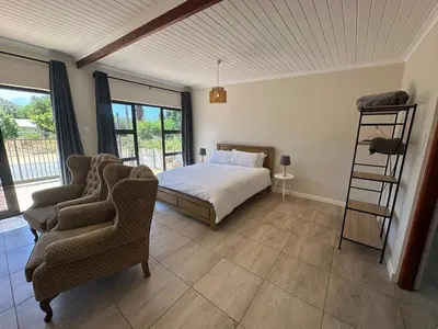 a bedroom with a bed and two chairs at Worcester accommodation Putt and Stay in Worcester
