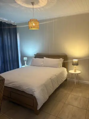 a bedroom with a large bed and a chandelier at Worcester accommodation Putt and Stay in Worcester