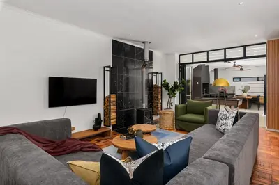 a living room with a couch and a table at Luxury Family Villa with Pool, Gym & Bonfire Area in Cape Town