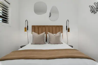 a bedroom with a bed with white sheets and pillows at Luxury Family Villa with Pool, Gym & Bonfire Area in Cape Town