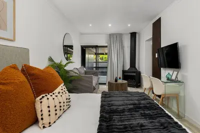 a bedroom with a bed and a living room at Luxury Family Villa with Pool, Gym & Bonfire Area in Cape Town