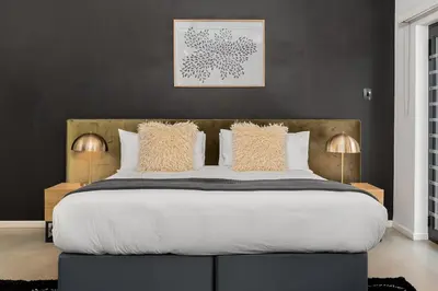 a bedroom with a large bed with white sheets and pillows at Luxury Family Villa with Pool, Gym & Bonfire Area in Cape Town