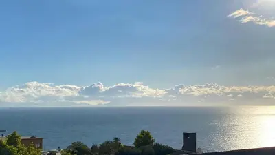 a view of the ocean with clouds in the sky at Ocean & Mountain View Apartment in Gordonʼs Bay