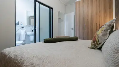 a bedroom with a bed with a view of a bathroom at AlimamaSpaces The Fynbos Chelsea in Cape Town