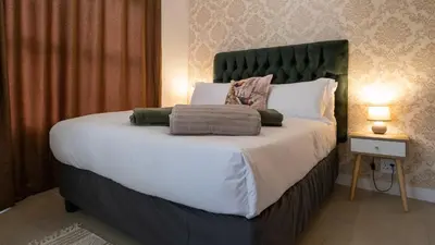a bedroom with a large bed with white sheets and pillows at AlimamaSpaces The Fynbos Chelsea in Cape Town