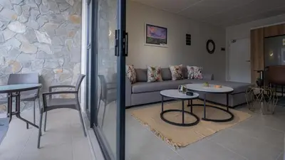 a living room with a couch and two tables at AlimamaSpaces The Fynbos Chelsea in Cape Town
