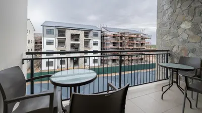 a balcony with a table and chairs and a balcony with buildings at AlimamaSpaces The Fynbos Chelsea in Cape Town