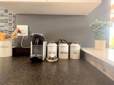 a kitchen counter with three coffee cups on it at Loft Escape in Onrus with Hot Tub- 2km from beach in Hermanus