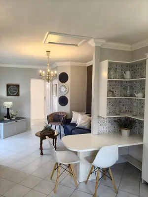 a living room with a table and chairs and a couch at Strand and Sea Cottage in Strand