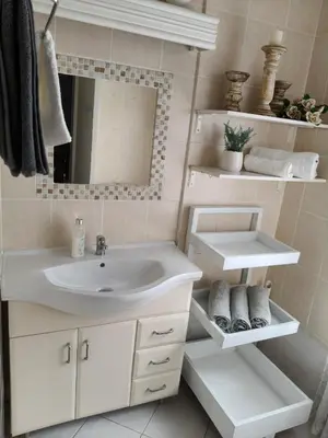 a bathroom with a sink and a mirror at Strand and Sea Cottage in Strand