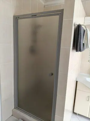 a shower with a glass door in a bathroom at Strand and Sea Cottage in Strand