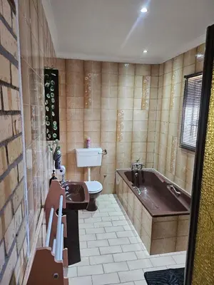a bathroom with a tub and a toilet and a sink at 12 on lake Grassy Park in Parkwood
