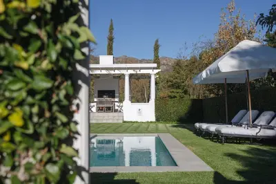 a backyard with a pool and an umbrella at Lily Pond House at Le Lude in Franschhoek